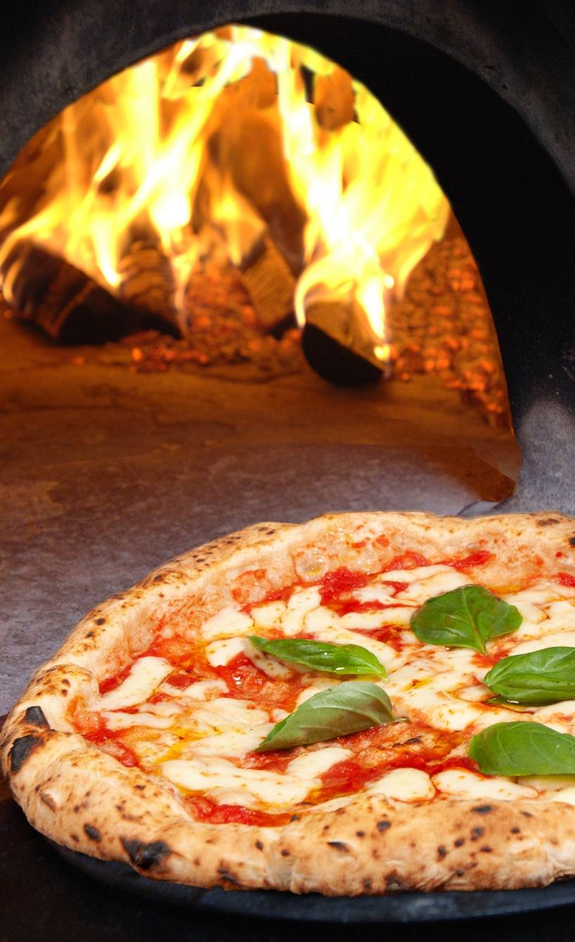 Eine Pizza Napoletana wird in einem Restaurant in Neapel aus einem Holzofen geholt