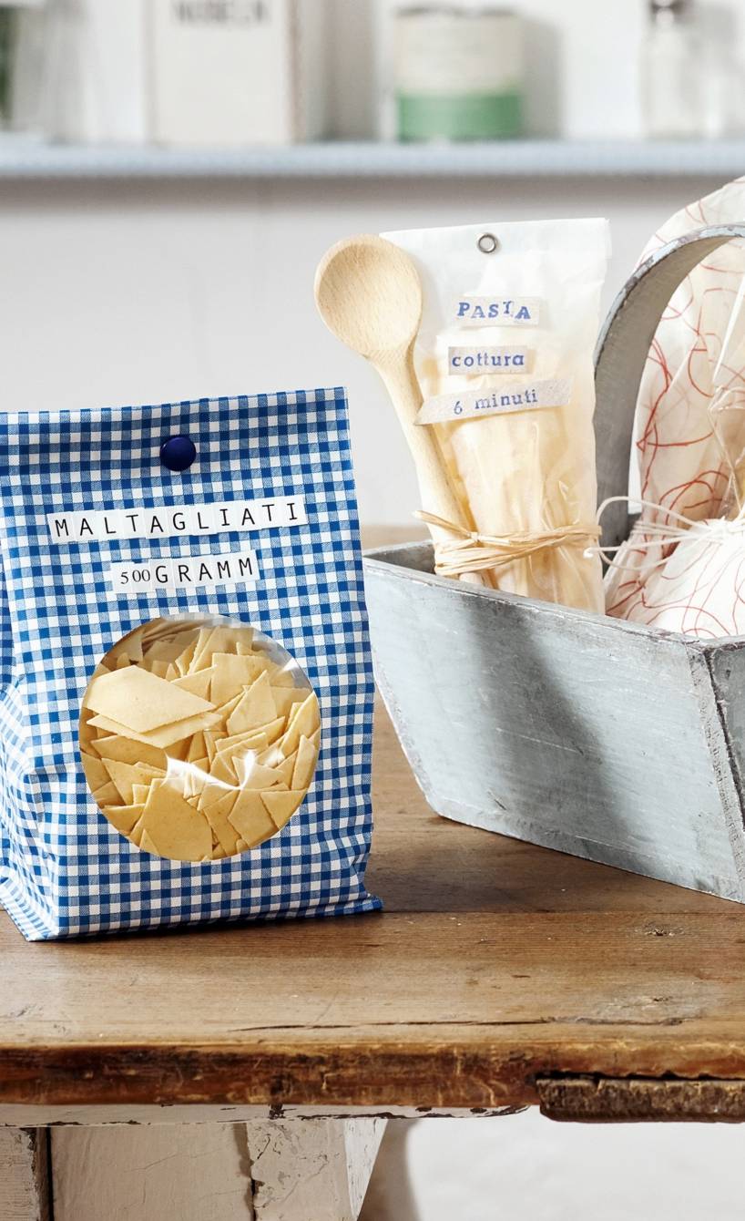Selbst gemachte Pasta in Geschenkverpackung  auf einem Holztisch in einer Küche