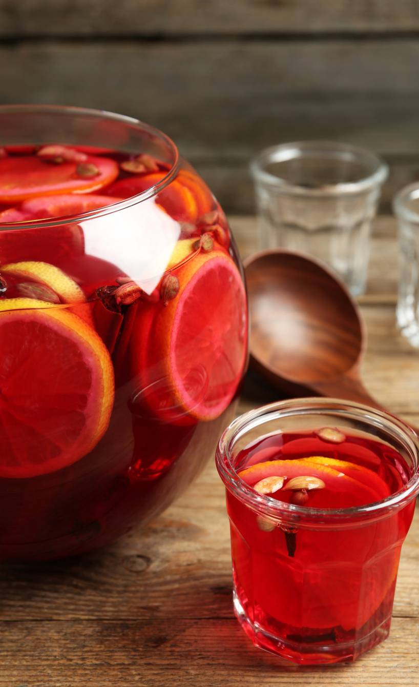 Silvesterbowle in einer Bowlenschüssel, daneben ein Glas befüllt