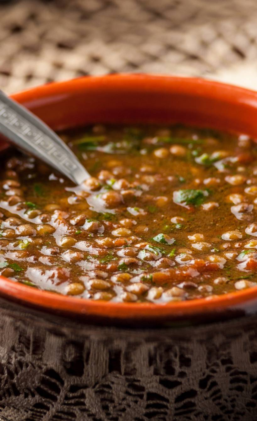 Zuppa di lenticchie nel coccio in einem Tontopf auf einem Tisch