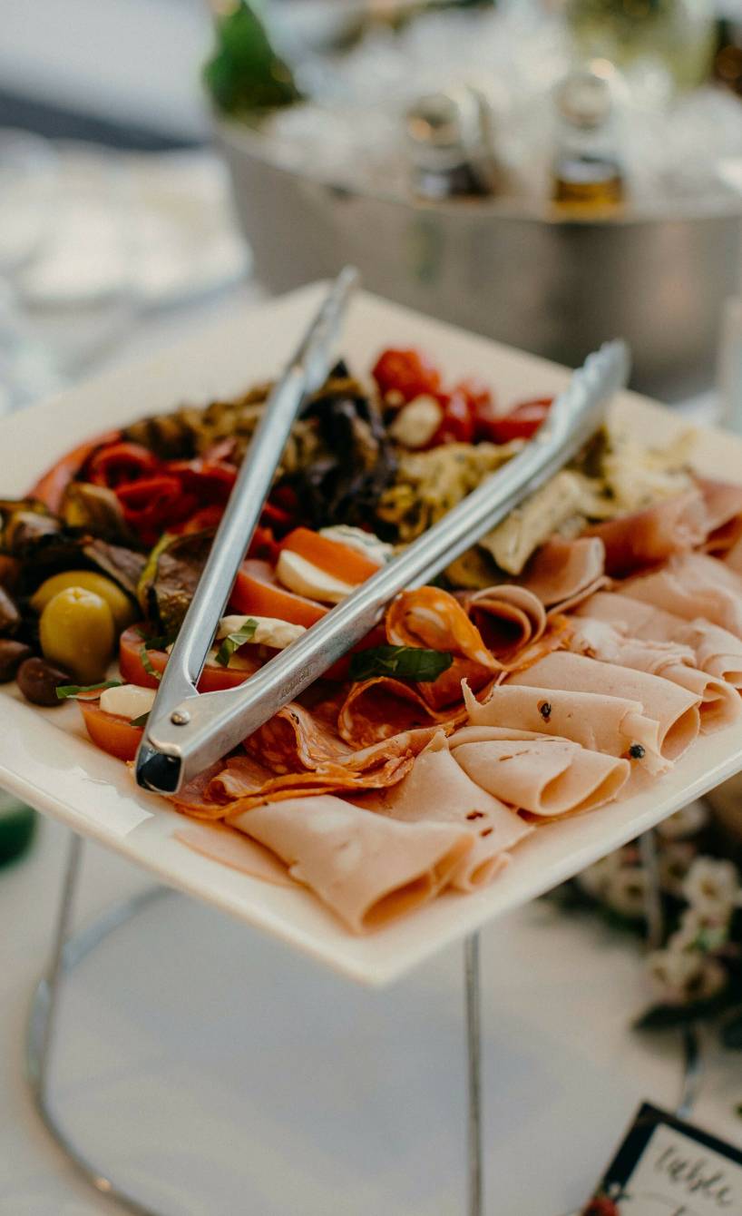 Quadratische Platte mit gemischten italienischen Antipasti auf einem festlich gedeckten Tisch