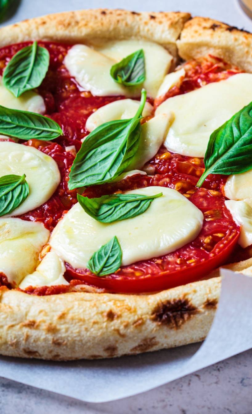 Vegane Pizza auf einem Stück Backpapier
