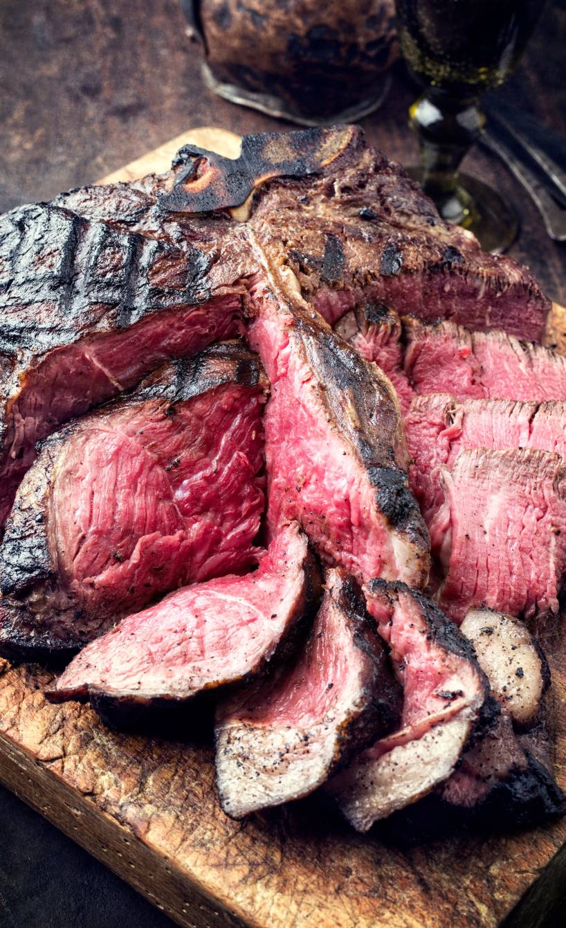 Steak Florentiner Art angeschnitten auf einem Holzbrett