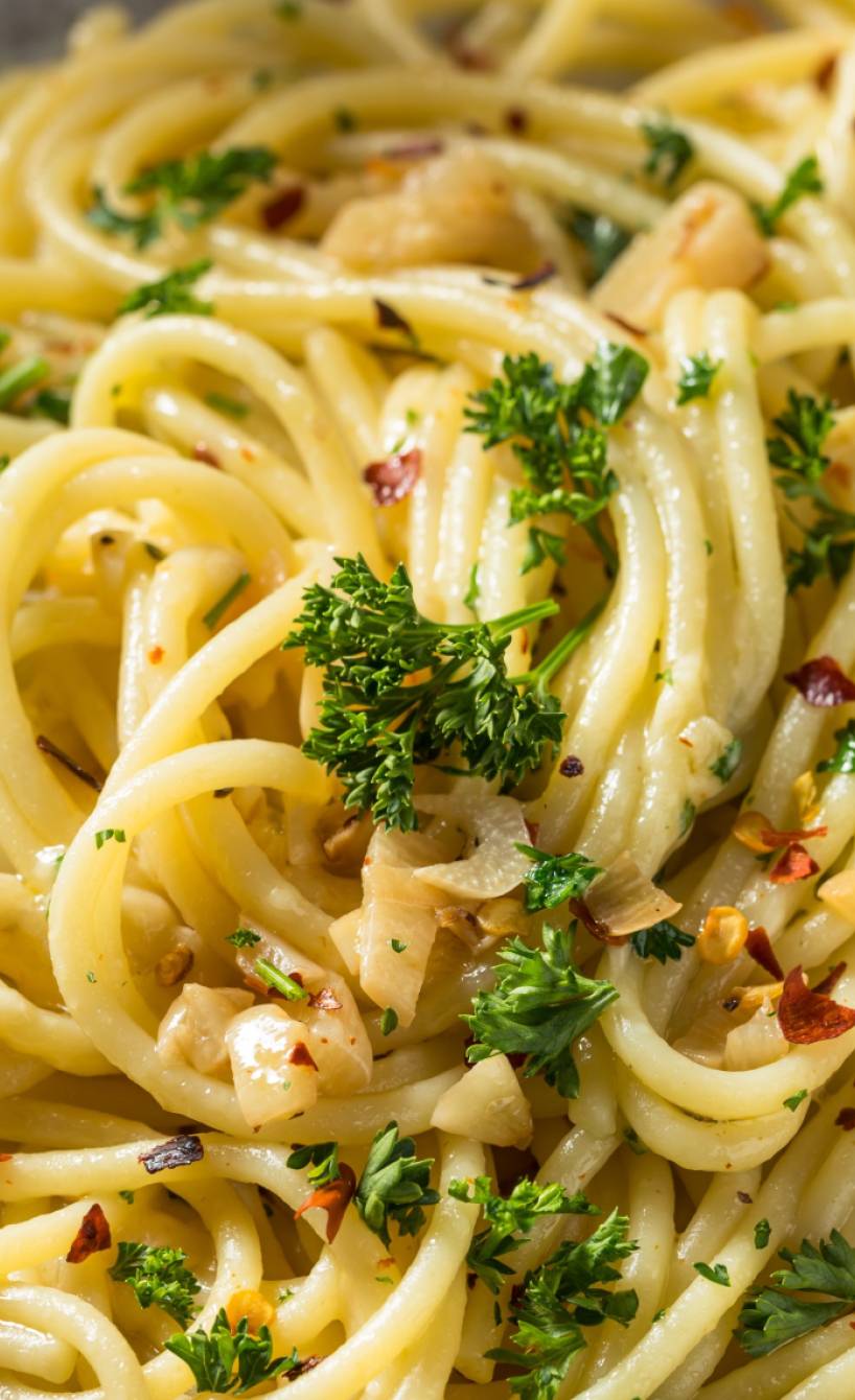 Spaghetti aglio e olio auf einem Teller angerichtet mit Olivenöl