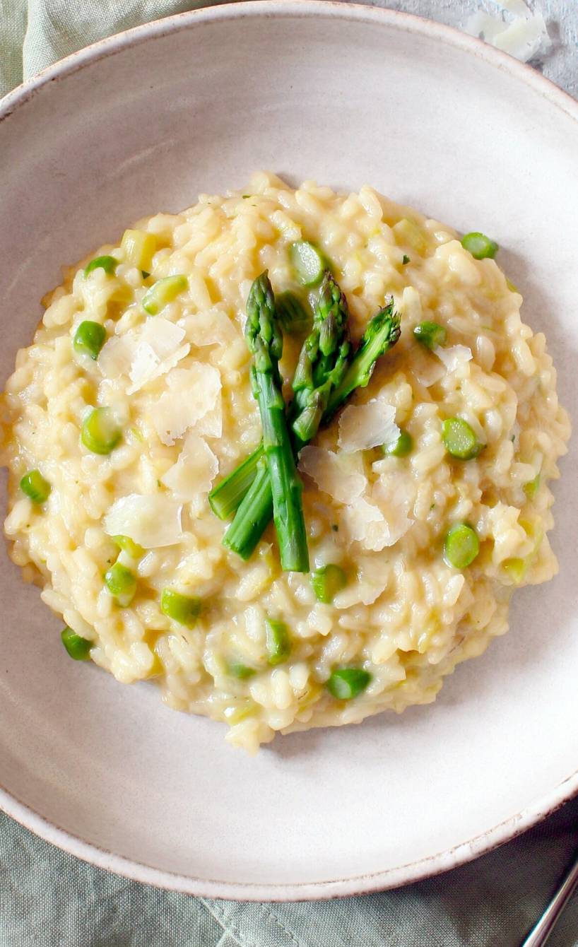 Spargelrisotto mit grünem Spargel angerichtet auf einem runden Teller