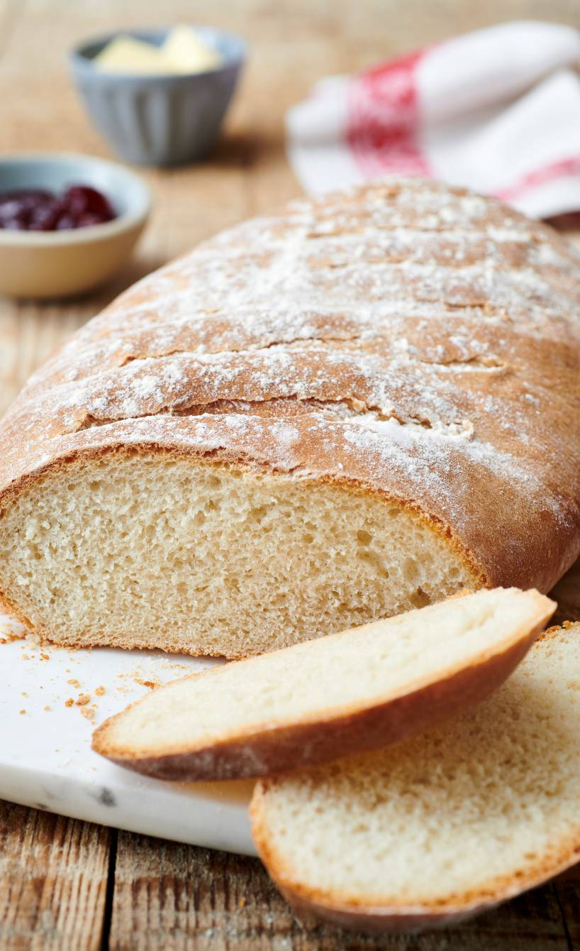 Ein Laib Pane Bianco, italienisches Weißbrot angeschnitten auf einem Marmorbrett