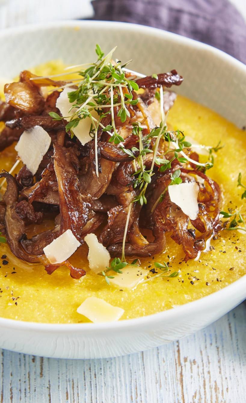 Polenta angerichtet mit gebratenen Austernpilzen, getoppt von Parmesan