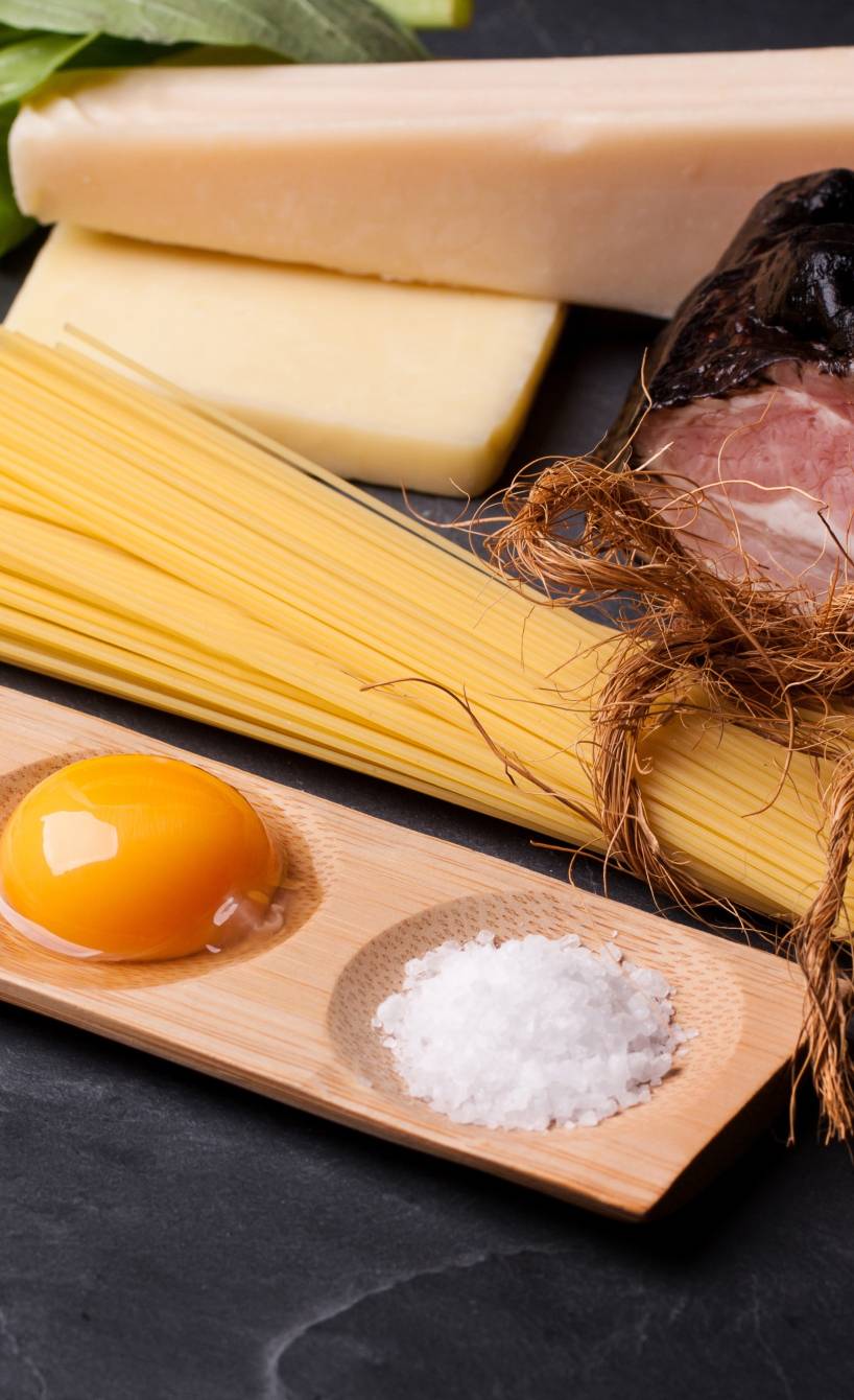 Guanciale, Pecorino, Eier, Gewürze für Carbonara und Spaghetti angerichtet auf einer Schieferplatte