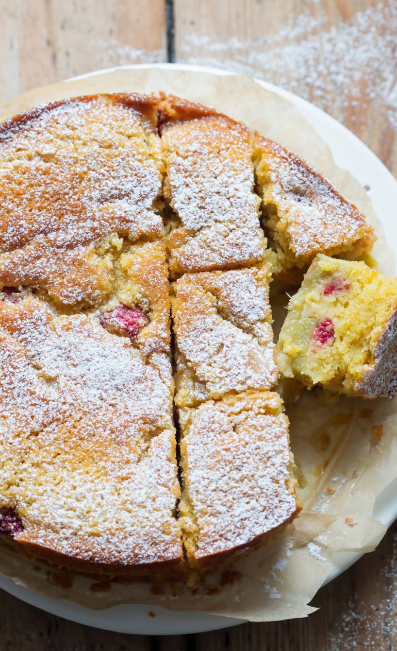 Runder Rhabarber-Polenta-Kuchen angeschnitten auf einem Teller
