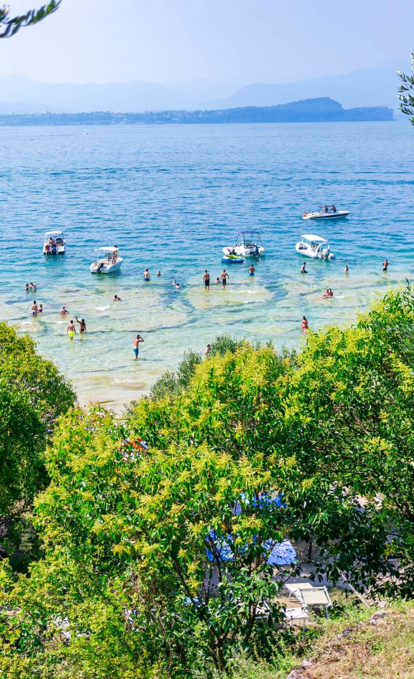 Blick auf Jamaica Beach am Gardasee durch Bäume