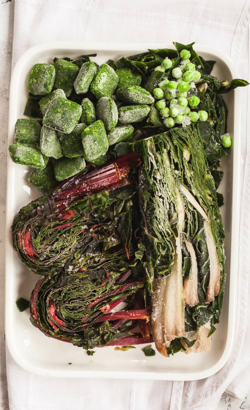 Verschiedene eingefrorene Frühlingsgemüse in Dosen wie Mangold auf einem Küchentisch