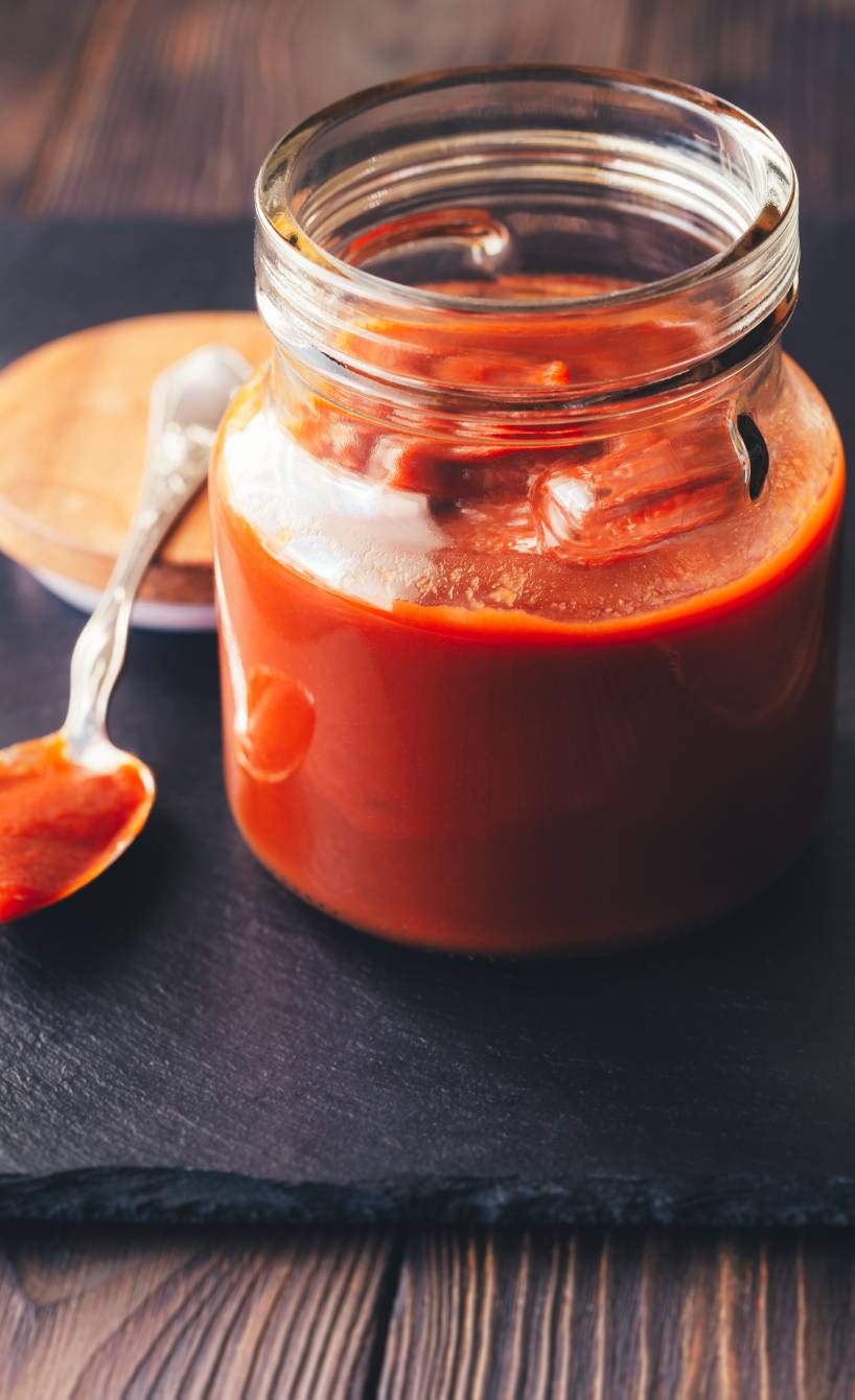 BBQ-Sauce mit Ramazotti in einem Einmachglas, daneben ein Löffel