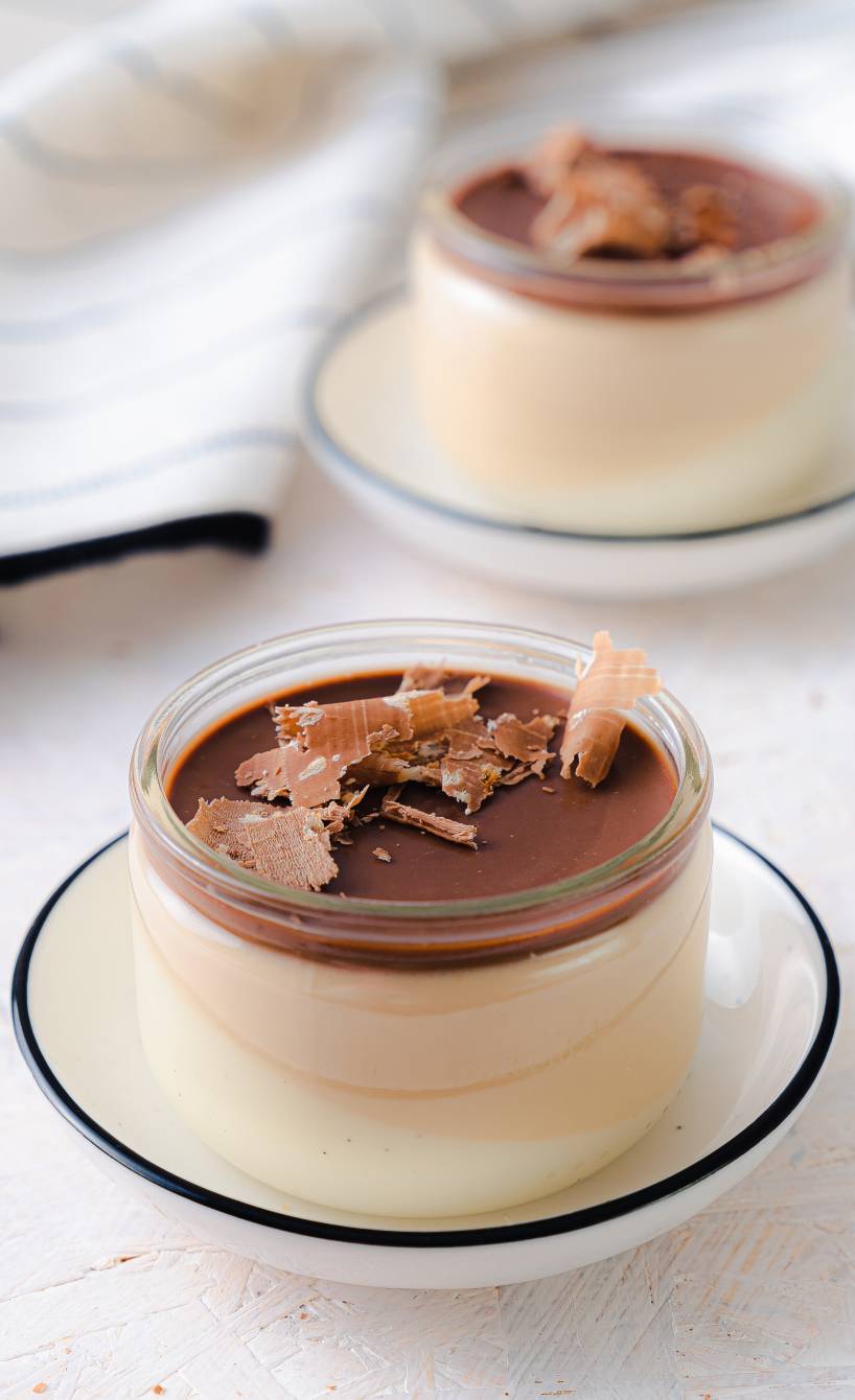 Espresso-Panna Cotta in zwei Gläsern getoppt mit Schokolade auf einem Tisch