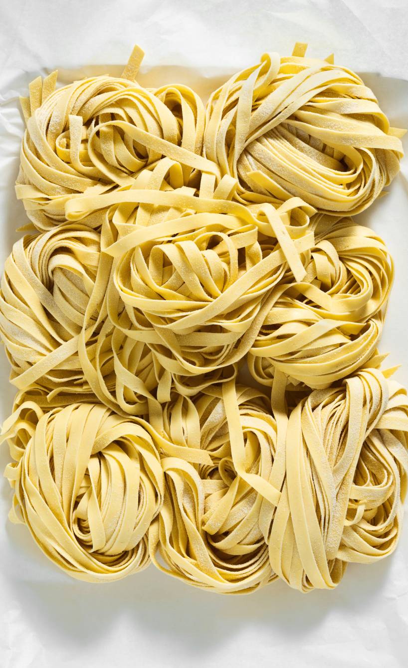 Selbst gemachte glutenfreie Nudeln in Tagliatelle-Form in Nestern auf einem Tisch