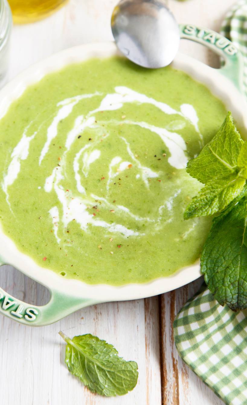 Kalte Basilikum-Minz-Suppe in einer Suppenschüssel garniert mit Minzblättern und getoppt von Crème fraîche