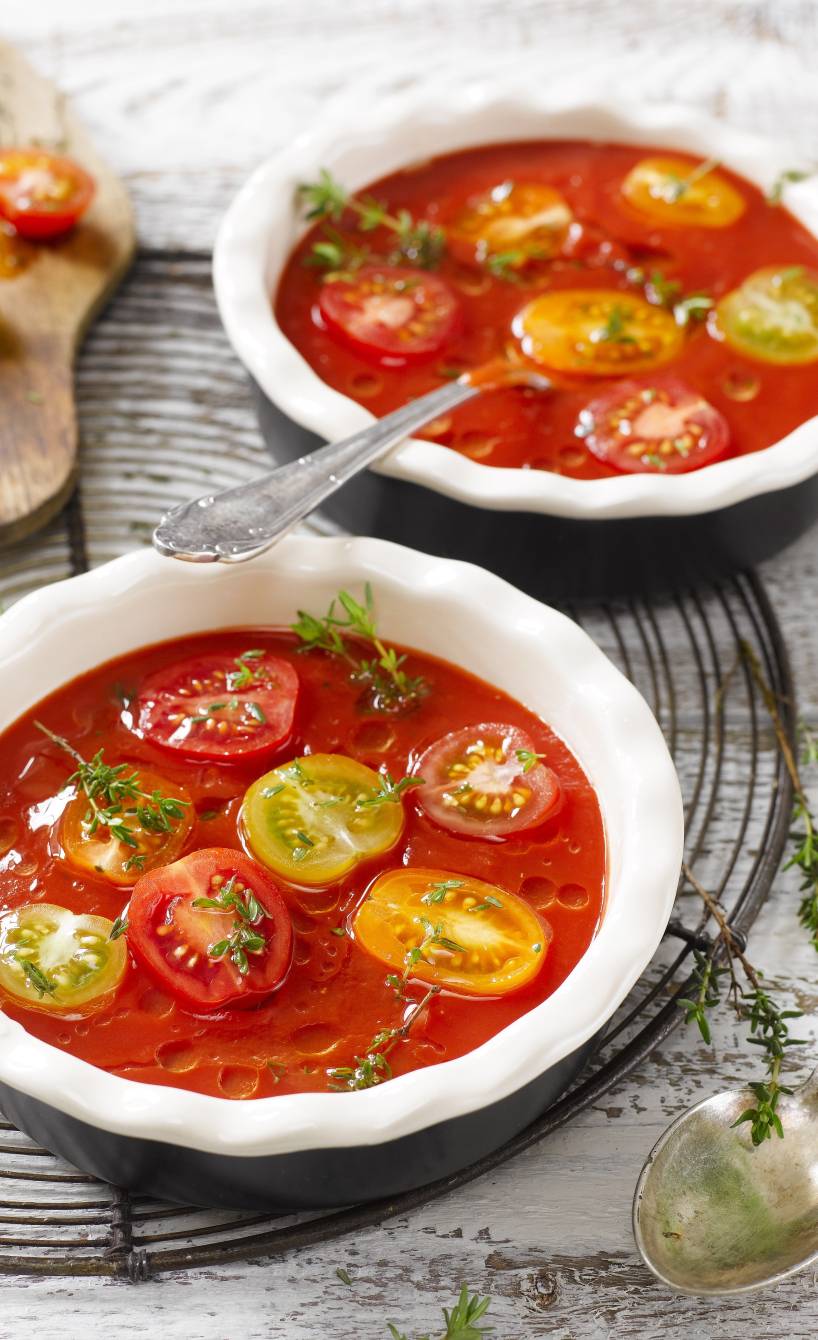 Zwei Suppenteller mit kalter Tomatensuppe auf einem Tisch