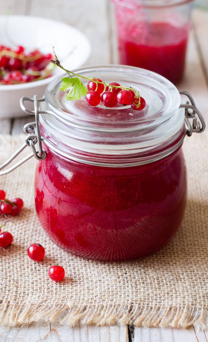 Selbst gemachte Johannisbeermarmelade in einem verschlossenen Einmachglas