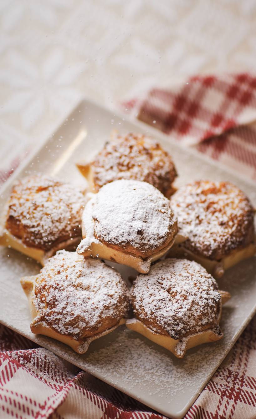 Safran-Ricotta-Küchlein gestapelt auf einem Dessertteller bestäubt mit Puderzucker