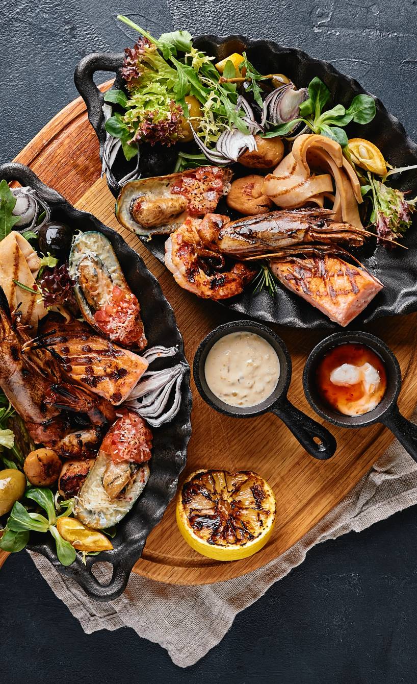 Schwertfisch und verschiedene Meeresfrüchte gegrillt angerichtet auf einer Platte