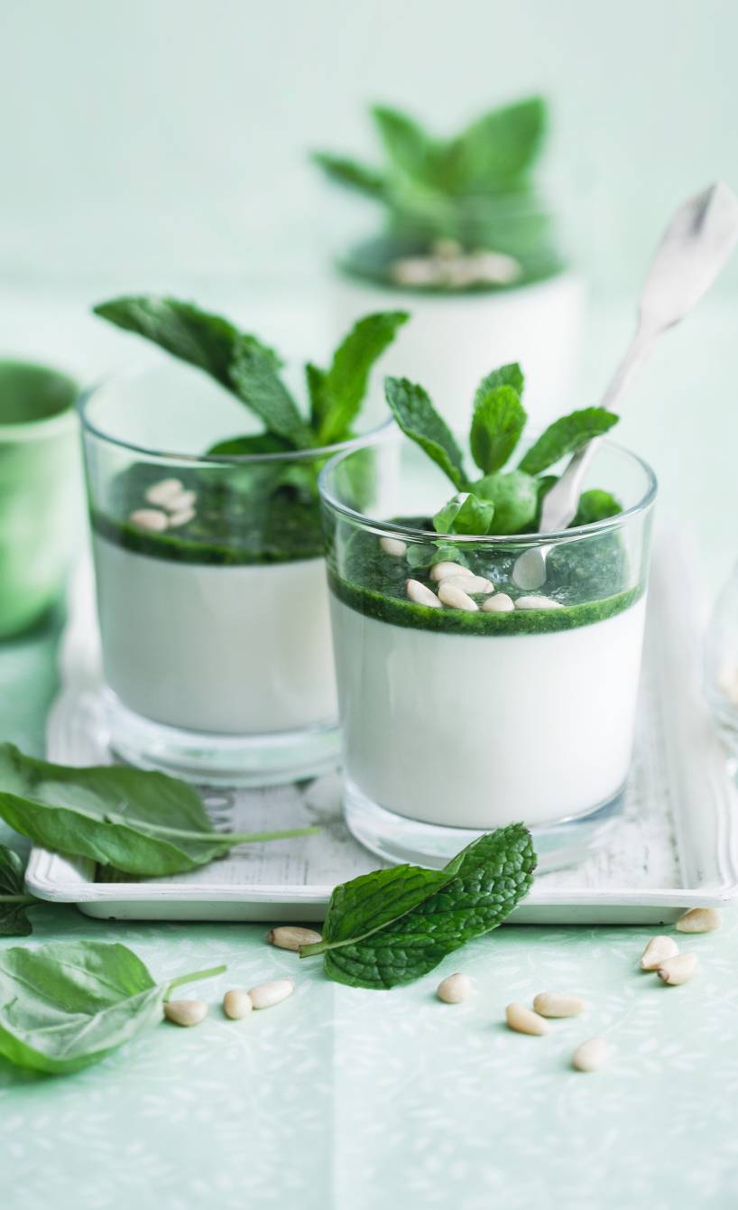Panna cotta in zwei Gläsern geschichtet mit süßem Basilikum-Pesto auf einem Tisch