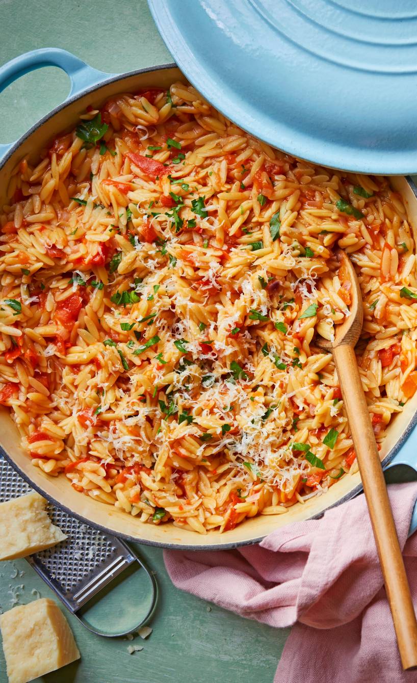 Topf mit One-Pot-Risoni, Tomatensoße, Feta und Parmesan auf einem Tisch