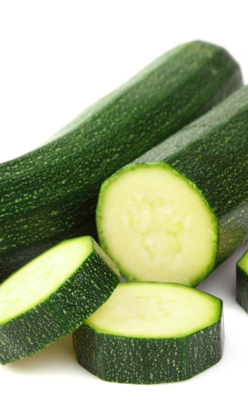 Zwei dunkelgrüne, längliche Zucchini der Sorte Black Beauty auf weißem Hintergrund Zwei dunkelgrüne, längliche Zucchini der Sorte Black Beauty auf weißem Hintergrund