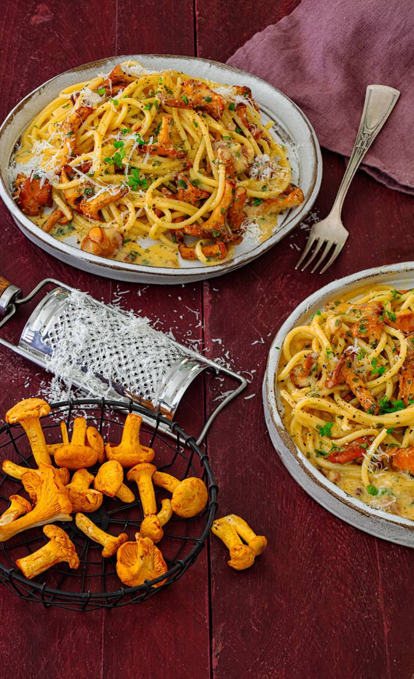 Original Spaghetti Carbonara mit Pfifferlingen angerichtet auf Pastatellern