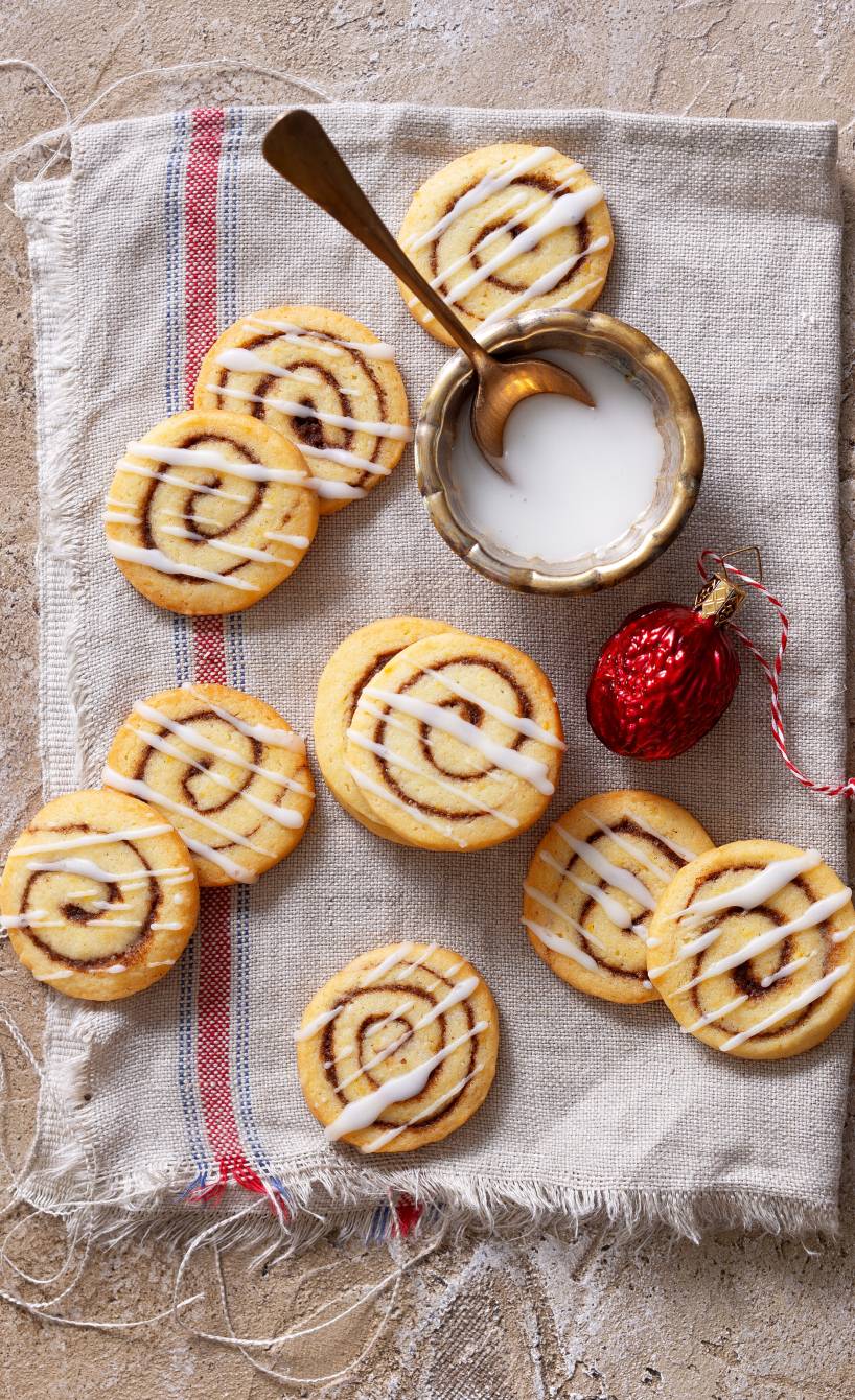 Merere Zimtschnecken-Plätzchen mit weißem Guss auf einem Küchentuch