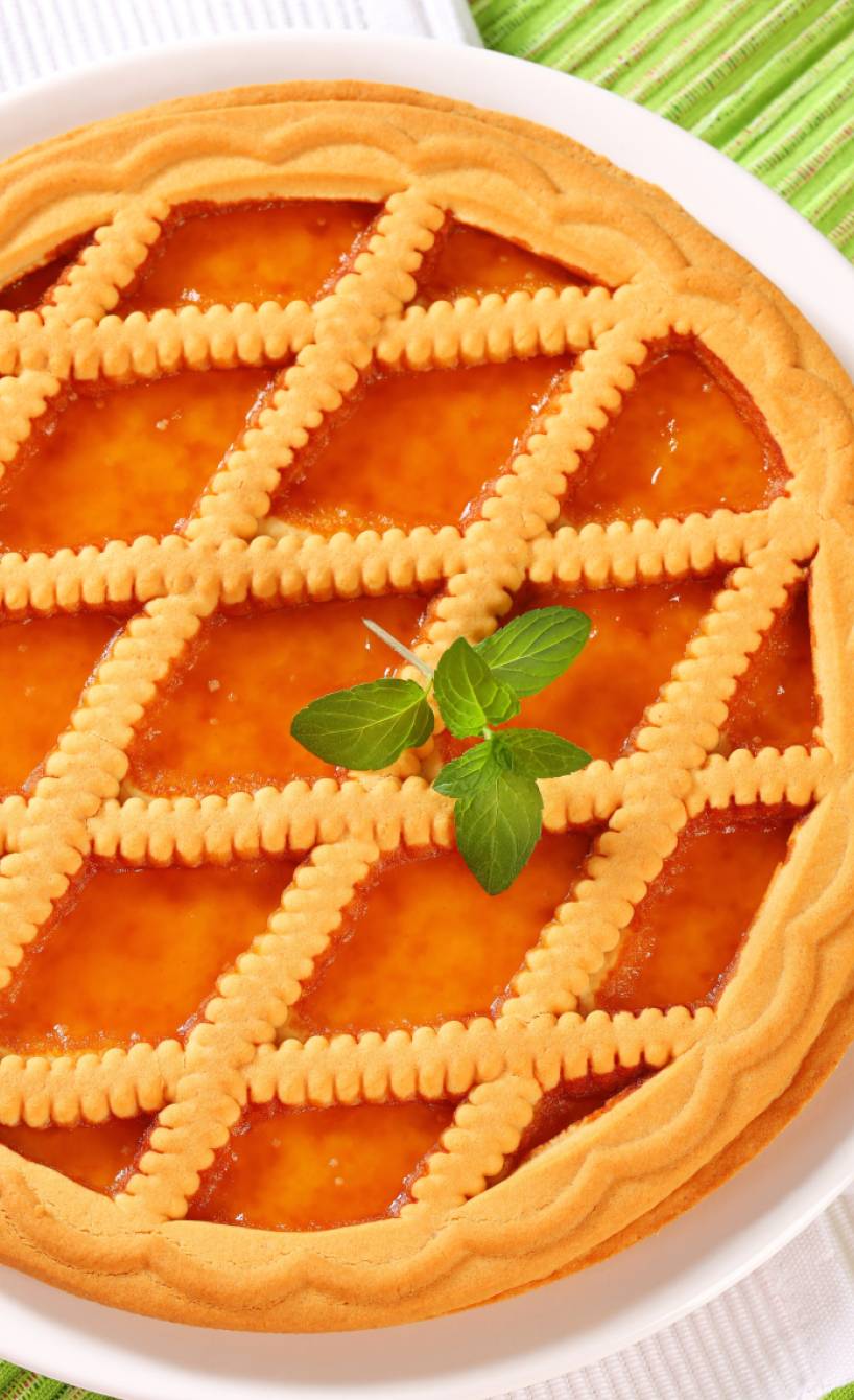 Runder italienischer Marmeladenkuchen mit Gitter auf einer Kuchenplatte