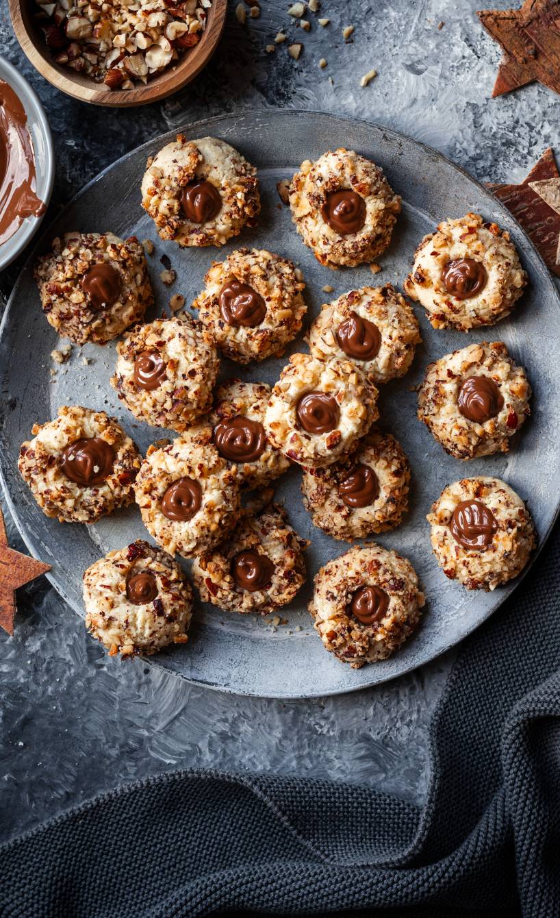 Selbst gebackene, gefüllte Nuss-Nougat-Plätzchen auf einem Weihnachtsteller