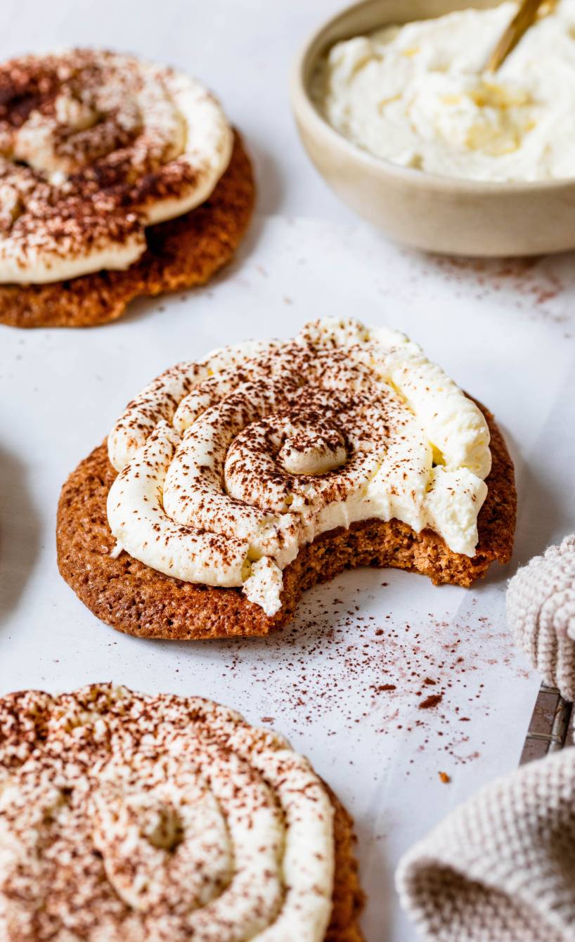 Selbst gebackene Tiramisu-Cookies getoppt mit mascarponecreme auf einem Stück Backpapier
