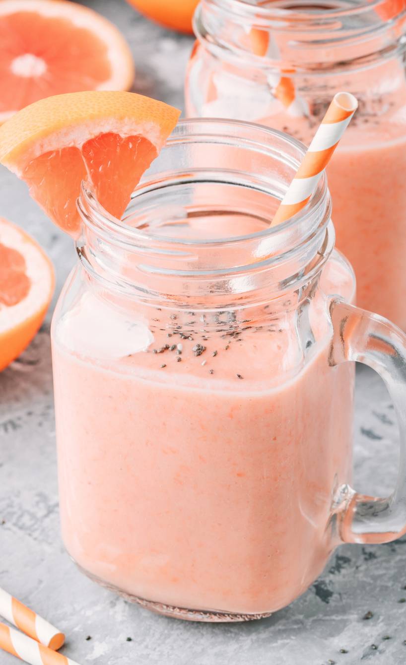 Grapefruit-Joghurt Smoothie mit Chiasamen in zwei Henkelgläsern auf einem Tisch