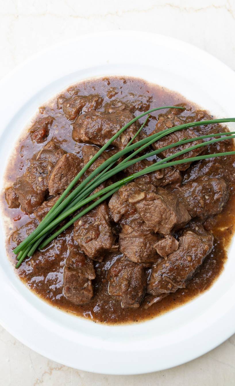 Toskanischer Rinderschmortopf Peposo mit viel dunkler Sauce auf einem tiefen Teller