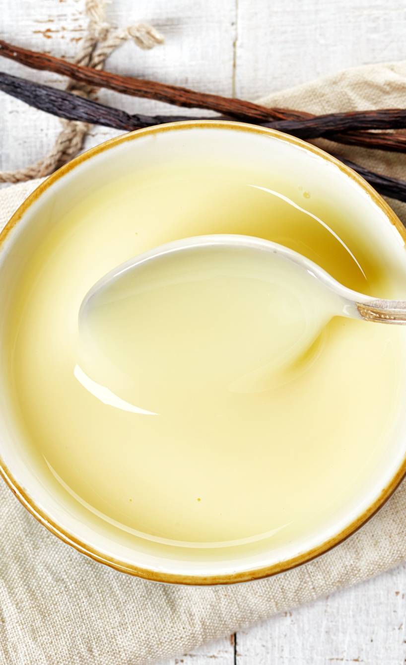 Selbst gekochte Vanillesoße in einer Sauciere wird gerade umgerührt