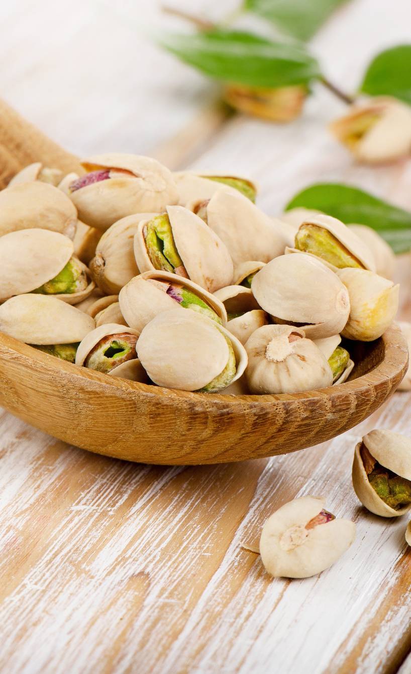 Ungeschälte Pistazien auf einem Holzlöffel