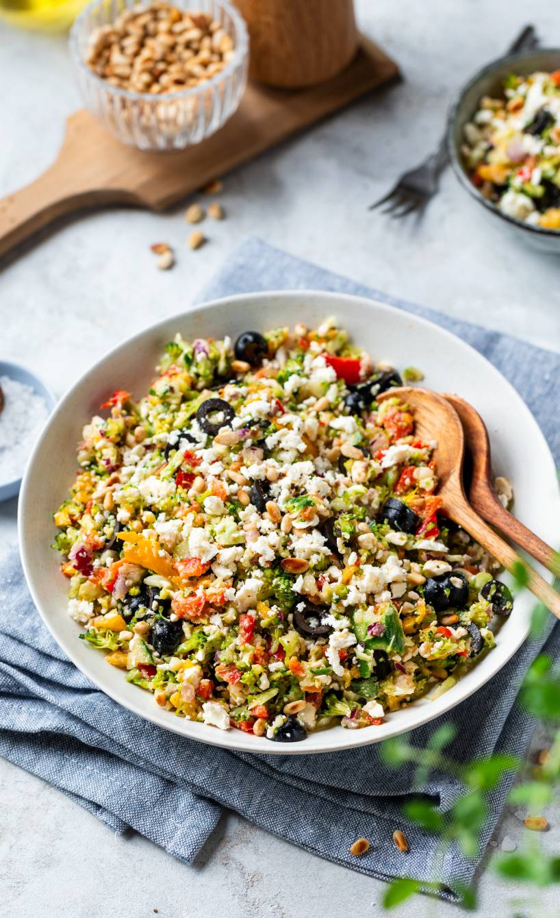 Rohkost bunter Brokkoli-Salat mit Oliven und Feta in einer Salatschüssel auf einem Tisch