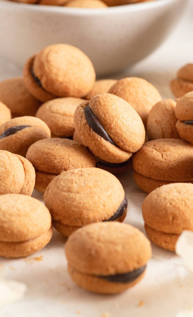 Selbstgebackene Damenküsse Haselnuss-Mürbeteig-Kekse Doppeldecker mit Schokofüllung auf einem Tisch