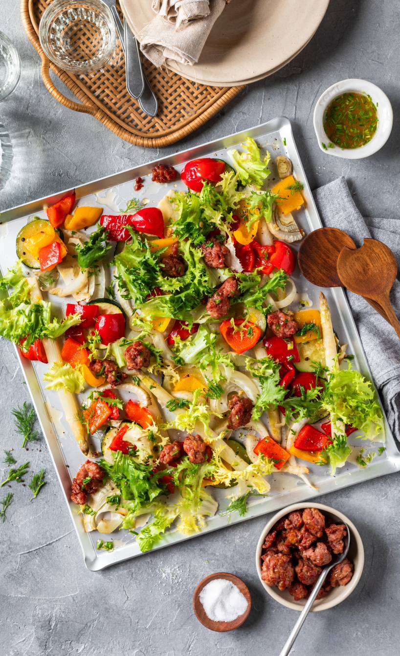 Gebackener Gemüsesalat mit Salsiccia auf einem Backblech