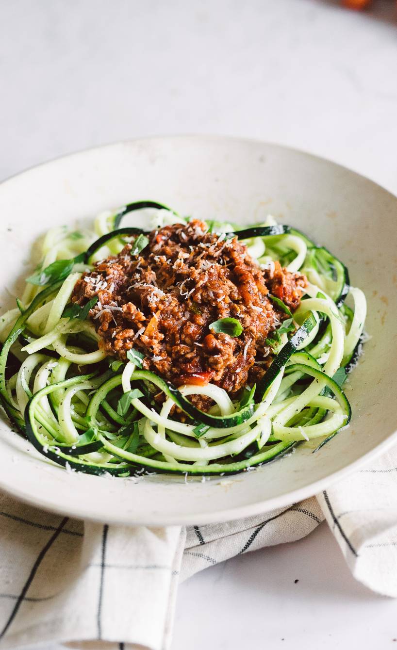 Spaghetti aus Zucchini angerichtet auf einem Pastateller mit Bolognese