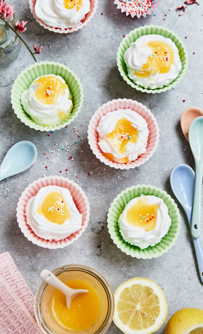 Selbstgemachte Osternester aus Baiser mit Lemon Curd auf einem österlich dekorierten Tisch