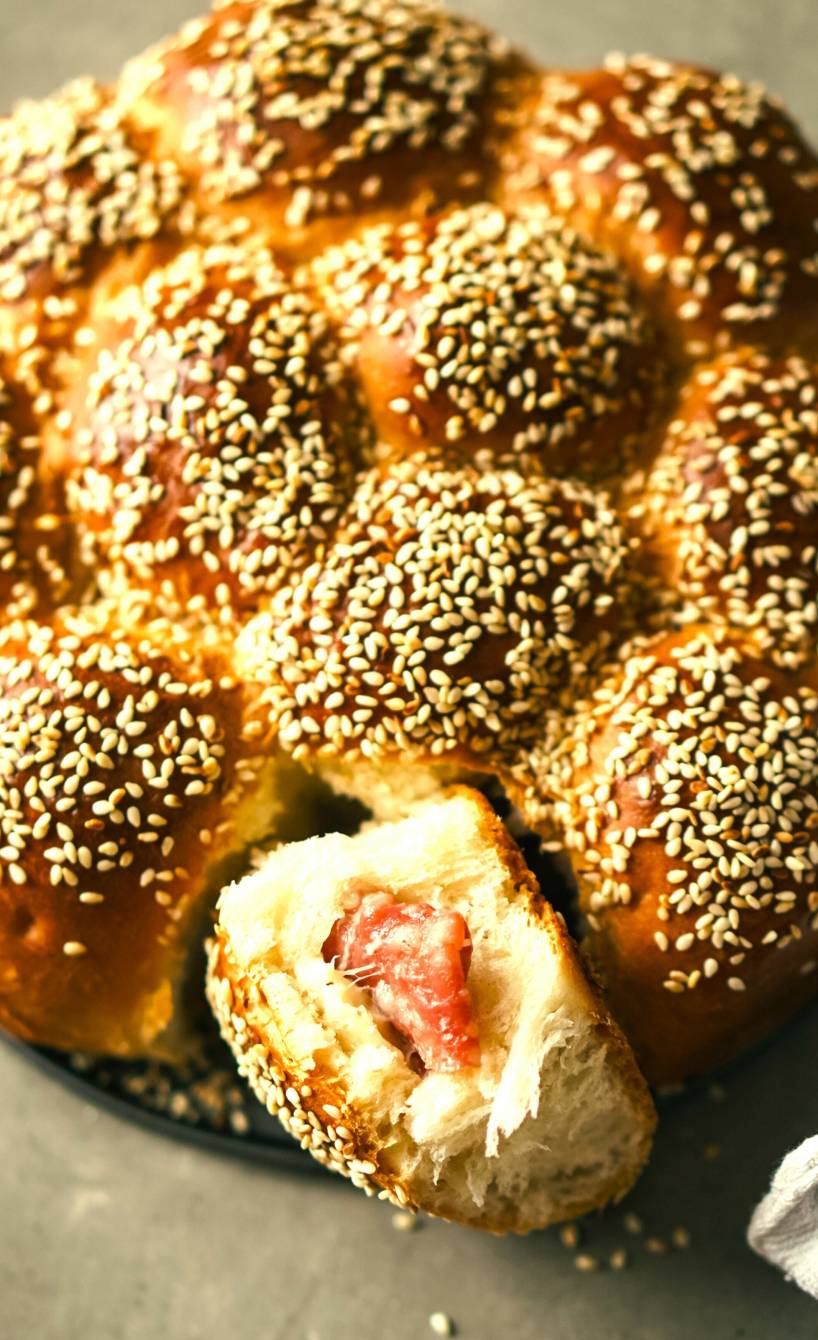 Rundes Danubio Salato gefülltes Zupfbrot mit Salami und Käse, eine Buchtel fehlend sodass man die Füllung sehen kann