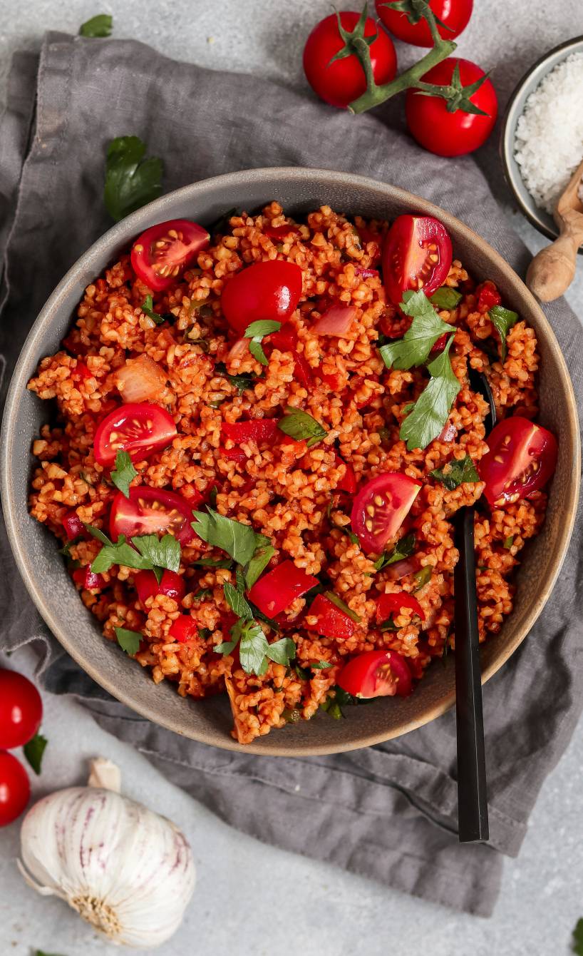 Veganer Bulgursalat mit Tomaten angerichtet in einer Salatschüssel