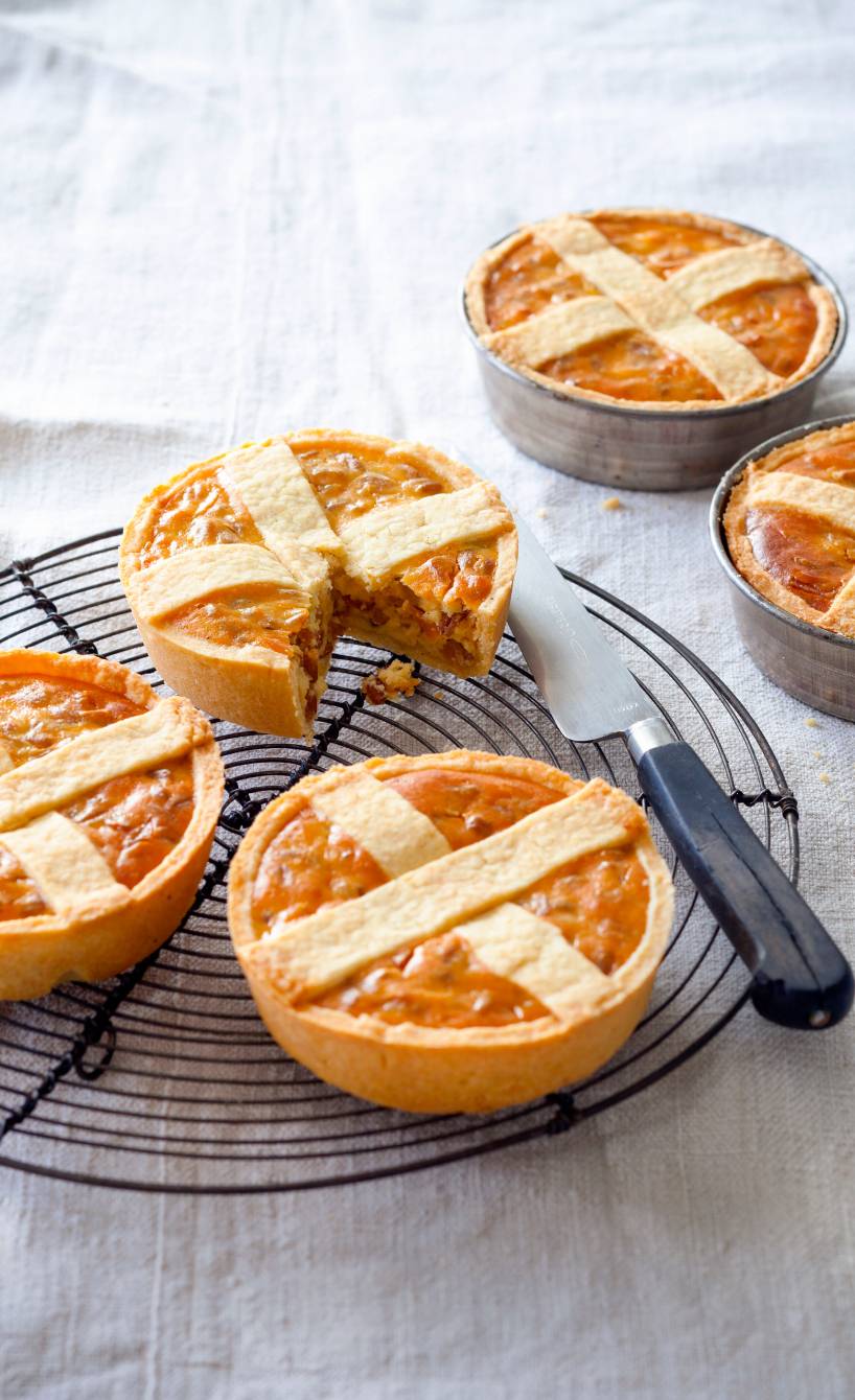 Mehrere selbstgebackene Mini Pastiera Napoletana Törtchen auf einem Kuchengitter