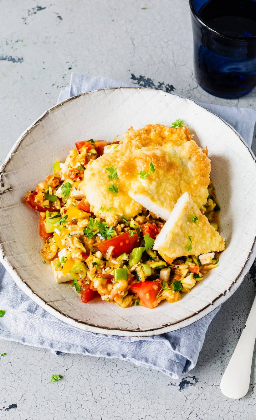 Zwei gebackene Hähnchen-Piccata in Parmesan-Panade angerichtet auf Feta-Gemüsesalat