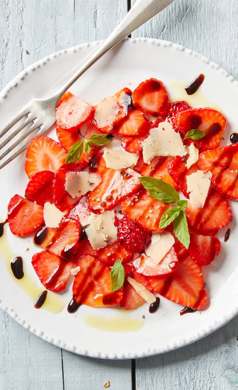 Erdbeer-Carpaccio angerichtet auf einem Vorspeisenteller mit Parmesan und Minze