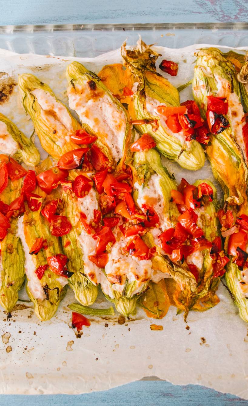 Mit Ricotta, Mozzarella und Parmesan gefüllte, im Ofen gebackene Zucchiniblüten auf einem Backgitter