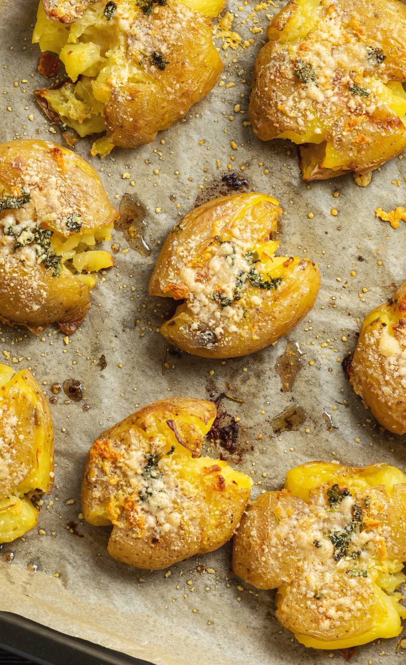 Ein Blech mit gebackenen Italian Smashed Potatoes mit Parmesan-Knoblauch-Kruste