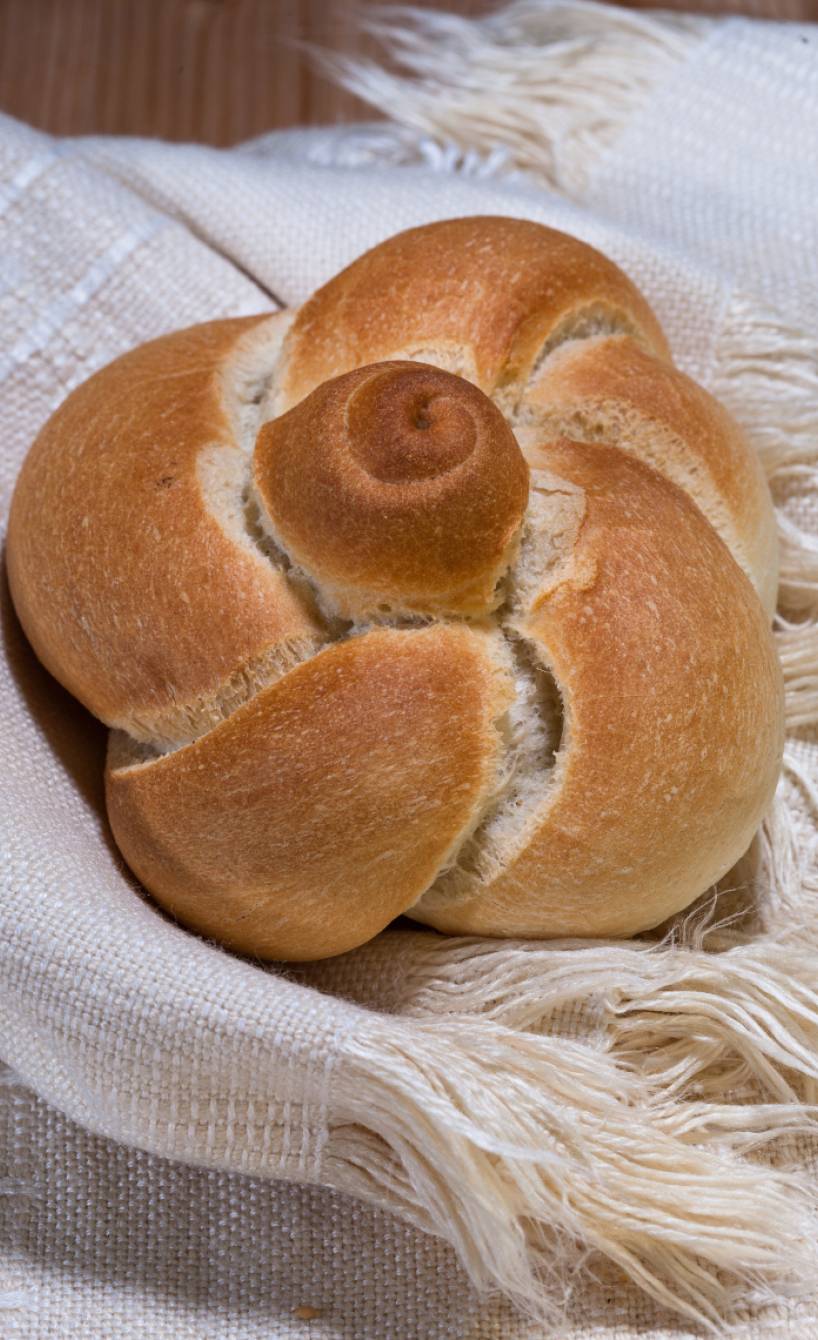 Ein selbstgebackenes Rosette Soffiate Michette Brötchen in Rosenform auf einem Tuch