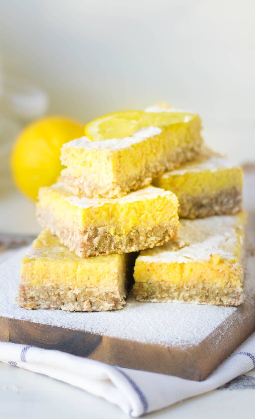 Glutenfreie Lemon Bars ohne Backen gestapelt auf einem Holzbrett