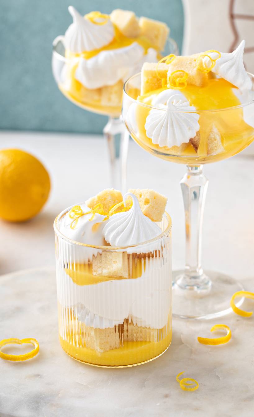 Drei Dessertgläser mit Limoncello Spritz-Tiramisu getoppt von Mini-Baisers